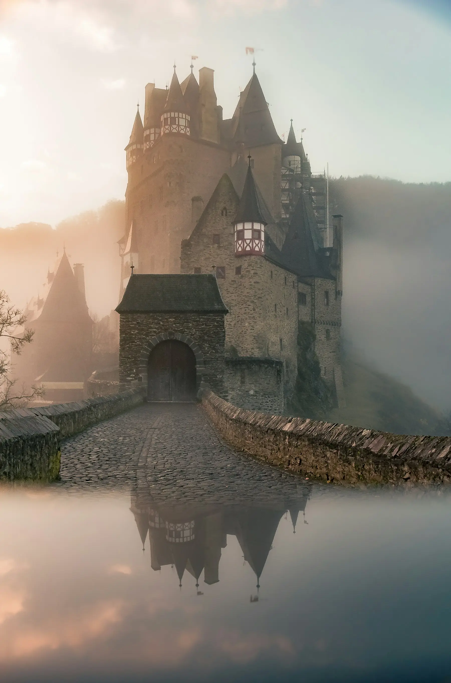 Burg Eltz mit Steinbrücke an einem nebligen Morgen