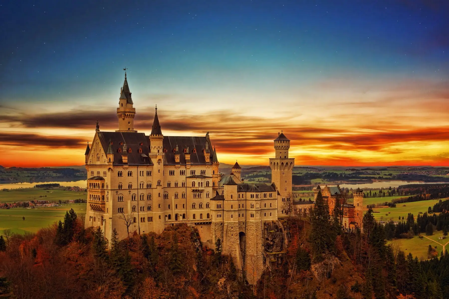 Schloss Neuschwanstein im goldenen Licht, umgeben von Wäldern